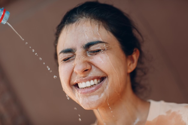 外の冷たい水でさわやかに熱中症に苦しむストレスの多い女性 天気の異常な暑さの概念