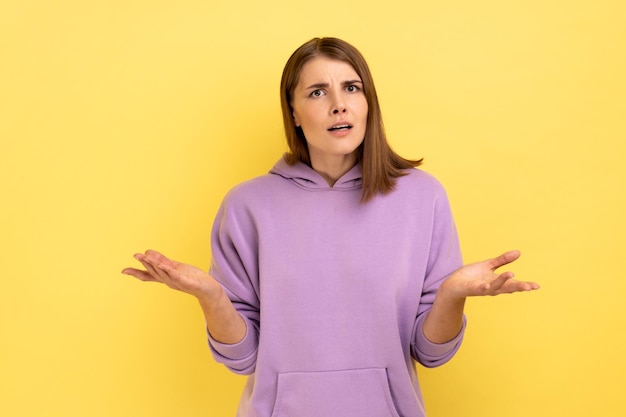 Stressed young adult woman standing raised arms and asking expressing negative emotions