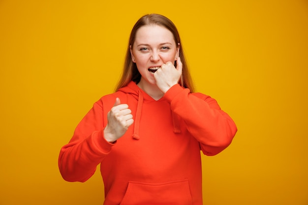 Stressed young blonde woman biting fist