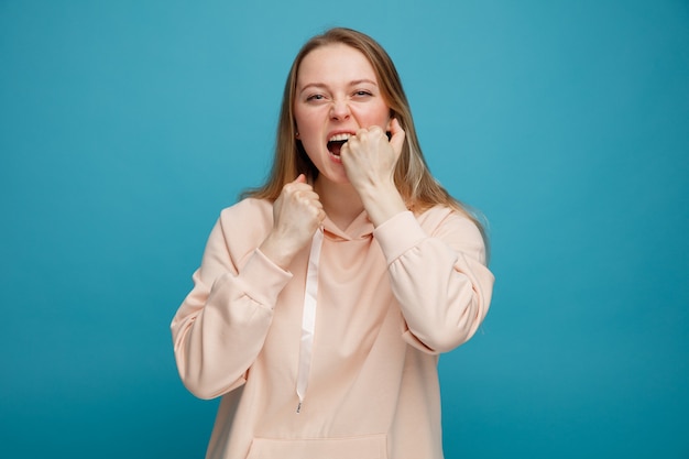 Stressed young blonde woman biting fist 