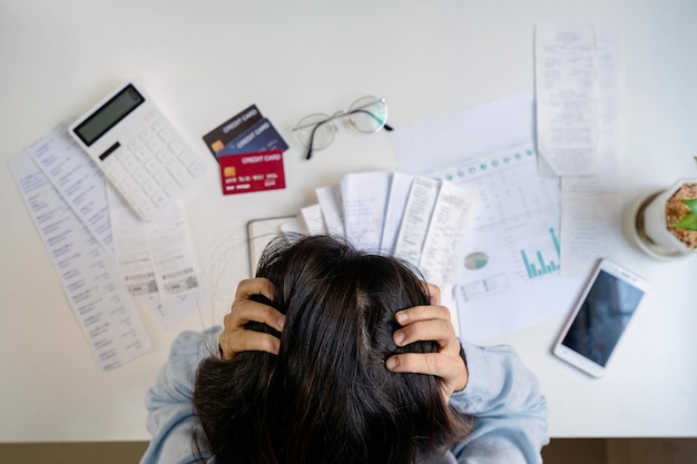 Photo stressed young woman calculating monthly home expenses taxes bank account balance and credit card bills payment income is not enough for expenses