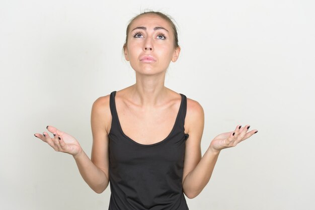 Stressed young woman with brown hair looking sad with arms raised