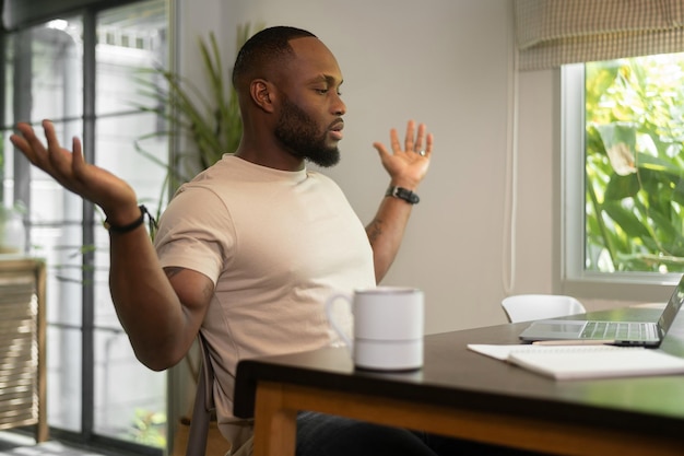 Stressante uomo afroamericano che lavora a casa sua