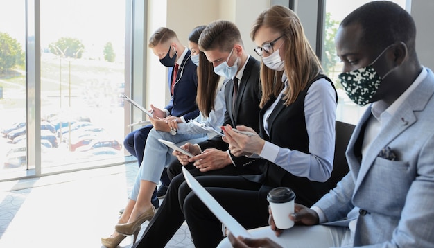 Stressful business people waiting for job interview with face mask, social distancing quarantine during COVID19 affect.