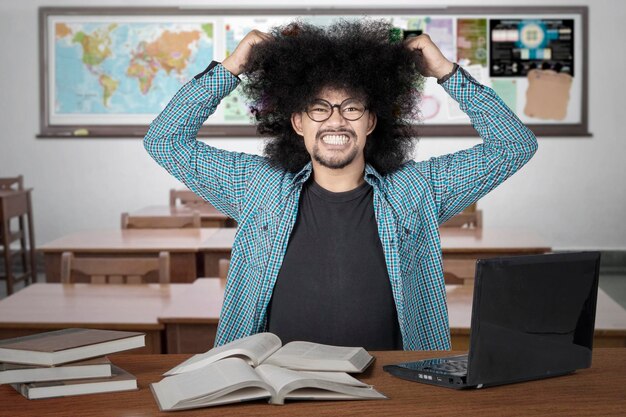 Photo stressful student pulling his hair in class