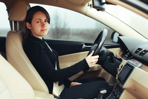 ハンドルに横になっている車の中でストレスや疲れた女の子