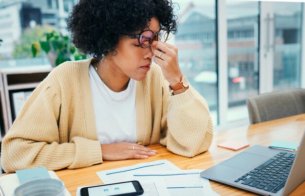 Foto stresshoofdpijnlaptop en vrouw in thuiskantoor met rekeningenschuld of uitgeput door belastingcontrole gefrustreerd vermoeidheid en moe meisje met pijn, burn-out of angst voor factuurbetalingscrisis op computer