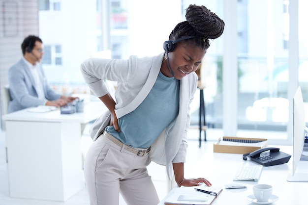 Stressmoe en callcentervrouw met rugpijn, burn-out of gezondheidsprobleem in klantenservice of verkoop Zwarte vrouwelijke crm of ondersteuningsagent of consultant met letsel, rugpijn of rekspieren