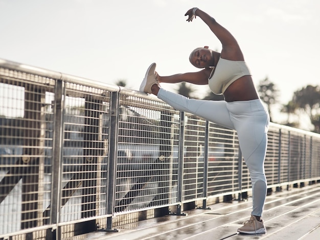 Stretch Its not optional Shot of a young woman stretching on a footbridge