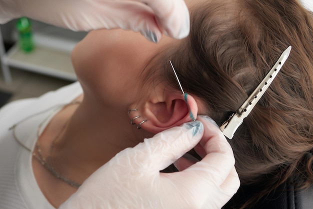 Foto lobo allungato piercing concetto grunge orecchio donna trafitto con tunnel a spina nera industriale e torre