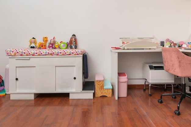 Stretcher with toys in a pediatric office with a desk and a modern scale for babies