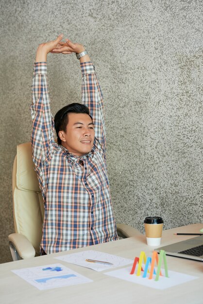 Stretching Asian businessman