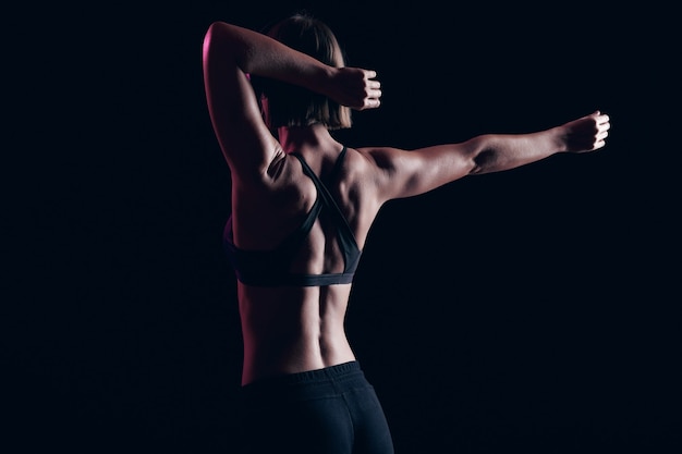 Photo stretching before workout. muscular girl with strong arms and abs listen music in headphones. healthy lifestyle