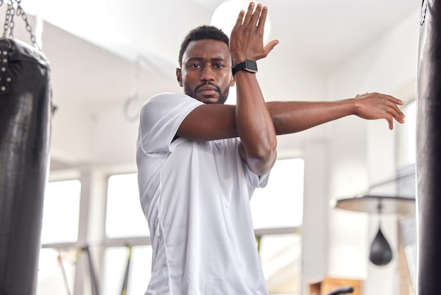 Stretching fitness en portret van een zwarte man in de sportschool om spieren en armen op te warmen Oefeningsfocus en Afrikaanse atleet die zich voorbereidt op een training klaar voor sport en cardio voor de gezondheid