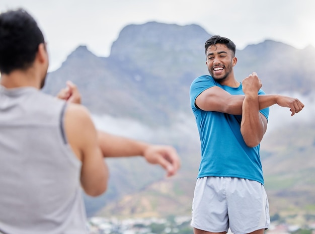 Stretching fitness en vrienden klaar om te rennen op een bergtraining en marathon in de natuur Gezondheid blij en atleet mannen met een warming-up voor sporten en trainen in de bergen