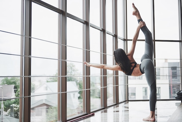 Stretching gymnast woman doing vertical split, twine.