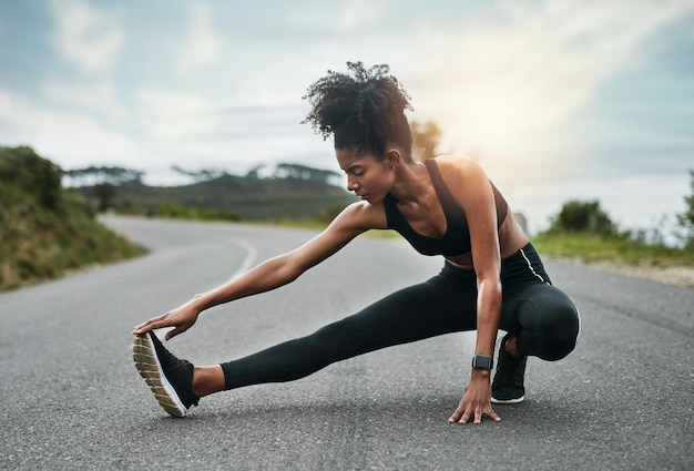 Foto lo stretching è importante quanto l'esercizio inquadratura a figura intera di una giovane sportiva attraente che si riscalda per un allenamento all'aperto