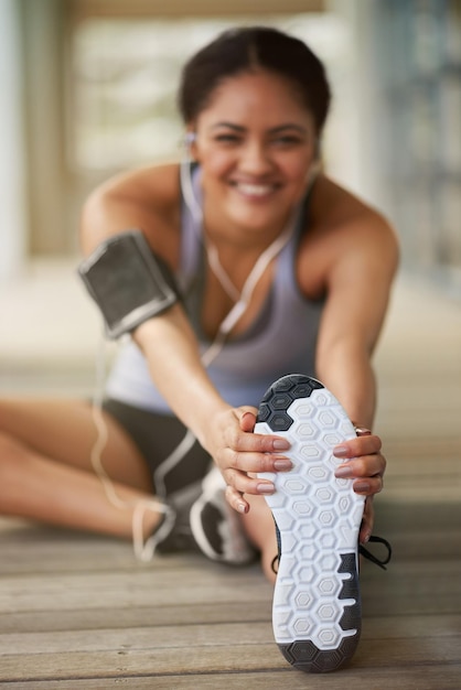 Stretching shoes or blur of girl runner streaming music to start training workout or outdoor exercise Leg warm up portrait or happy sports woman athlete listening to radio and fitness podcast