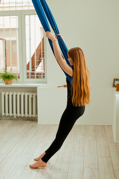 Stretching training. Gezonde levensstijl. Het jonge mooie meisje in zwarte eenvormig doet uitrekkende oefening. Akroyoga, yoga, fitness, training, sport.