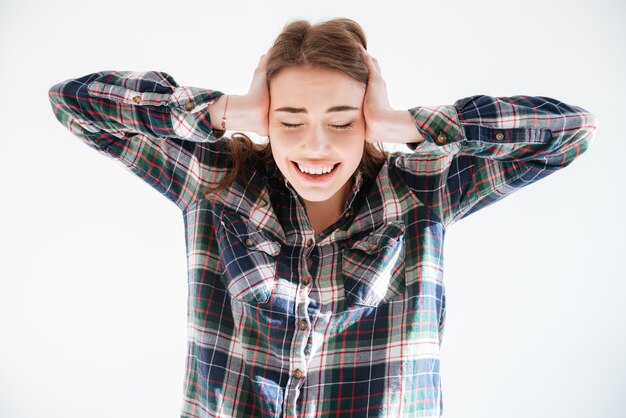 Stretted tensed young woman covered ears by hands