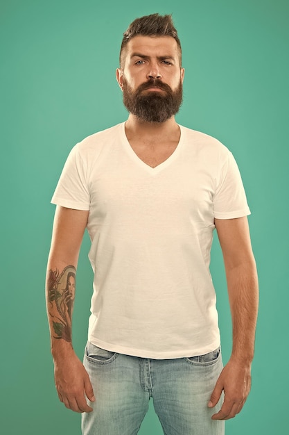 Strict and serious Beard fashion and barber concept Man bearded hipster stylish beard turquoise background Barber tips maintain beard Stylish beard and mustache care Hipster appearance