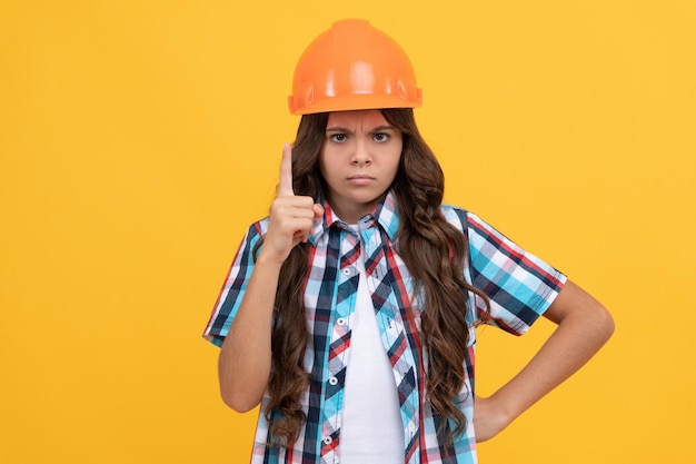 Strict teen girl with curly hair in construction helmet, expert.