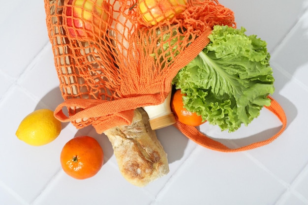 String bag with grocery on tile background