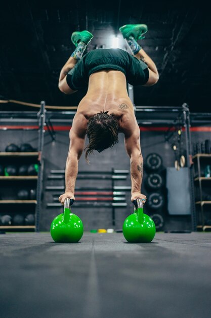 String Man exercising with kettlebells in a gym