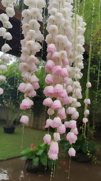 A string of white flowers hangs from a wooden structure.