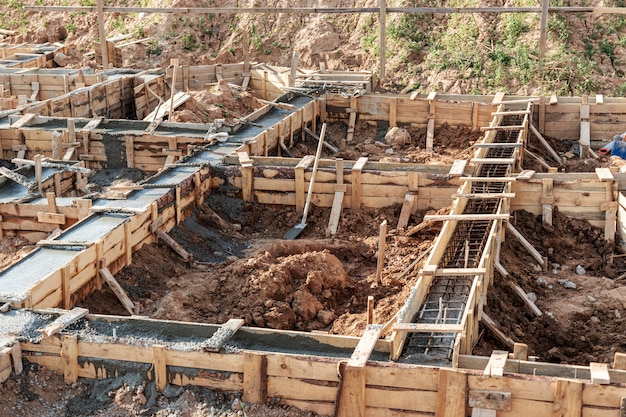 Strip foundations with formwork during the construction of a house. Reliable reinforced concrete foundation. Construction site.