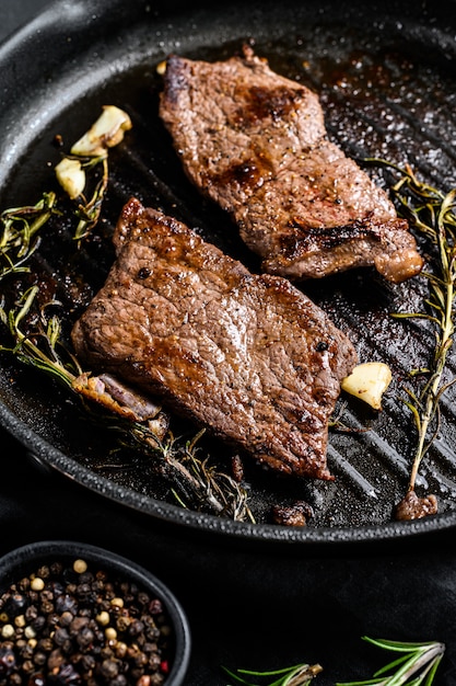 Strip loin steak in a frying pan. Grilled meat. Top view