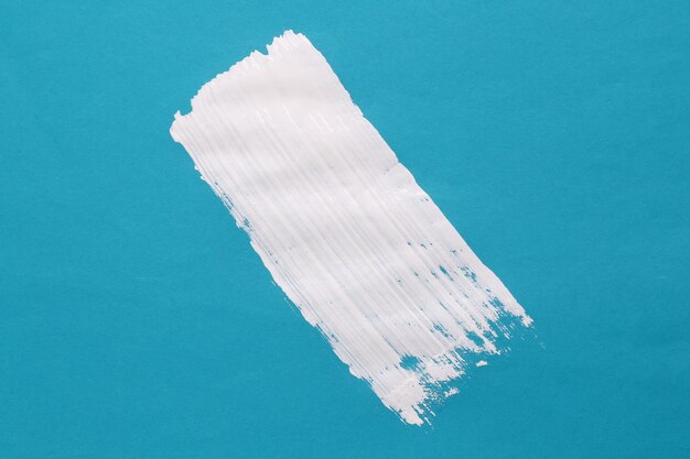 Stripe of white paint on blue background