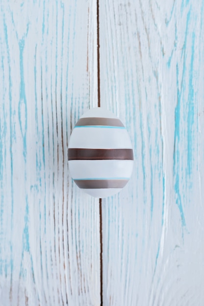 Striped egg on wooden background, Easter concept.