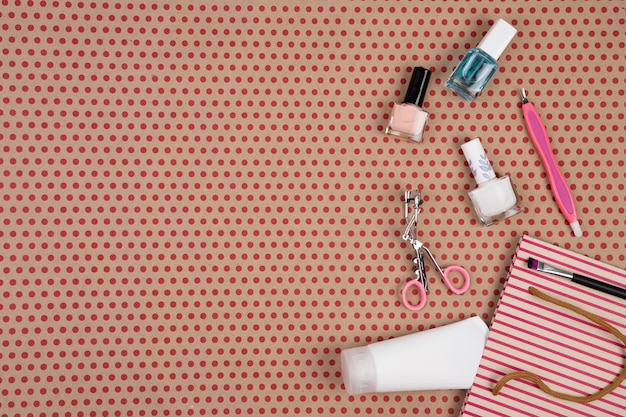 Striped gift bag with cosmetics set for makeup on craft paper background