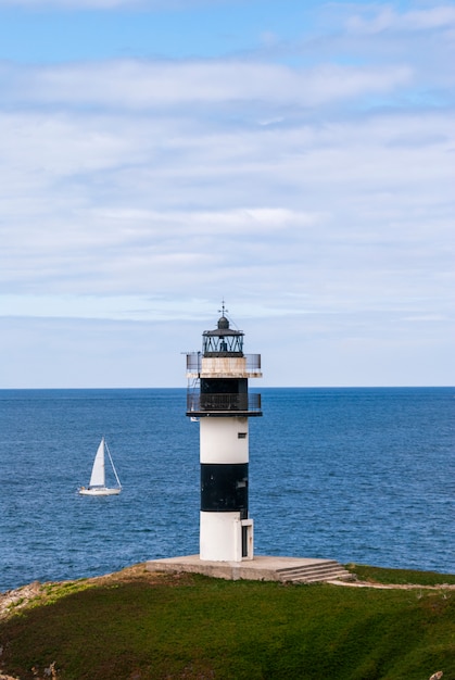 Striped lighthouse and sailing boat