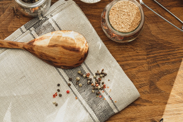 Striped linen napkin on wooden table with kitchen utensils close up