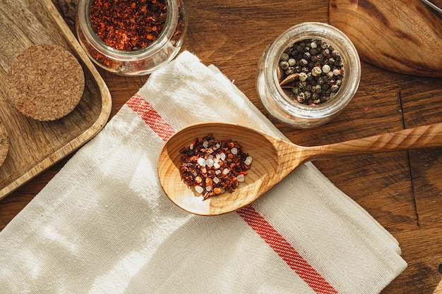 Striped linen napkin on wooden table with kitchen utensils close up