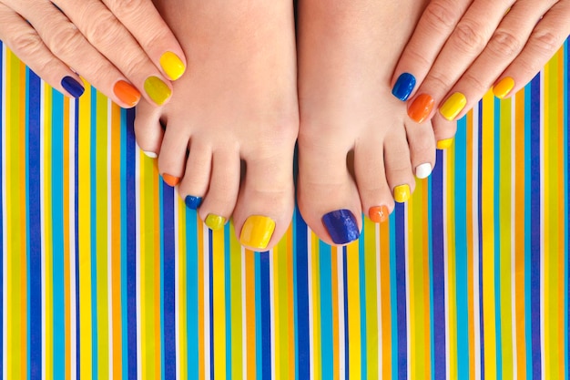 Striped multicolored pedicure and manicure