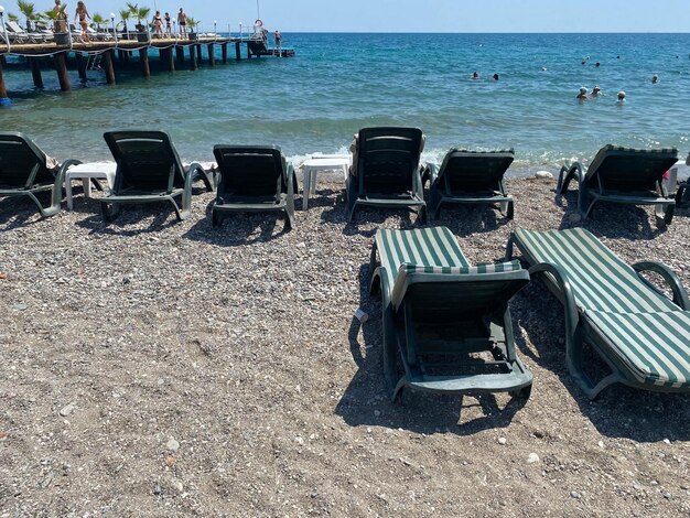 Striped plastic sun loungers on the beach on the sand under sun umbrellas