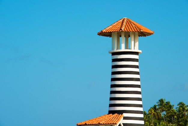 Foto faro bianco rosso a strisce sulla costa del mar dei caraibi. repubblica dominicana.