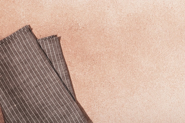 Striped textile brown serving napkin on beige plaster background
