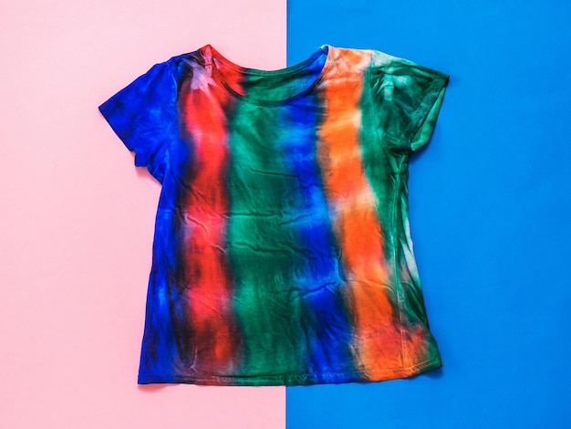 a striped tie dye tshirt on a red and blue background flat lay