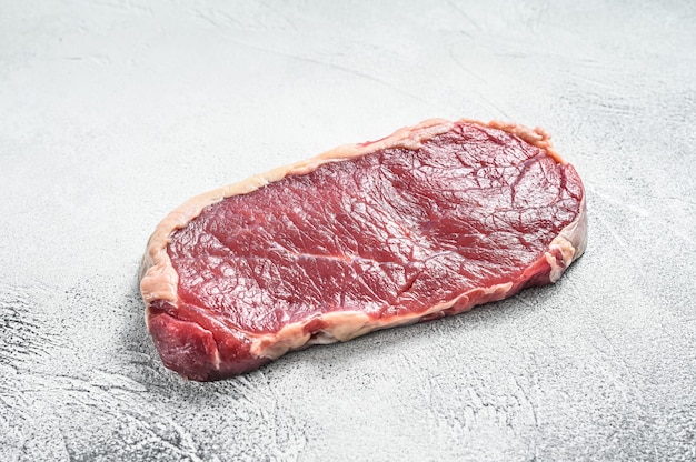 Striploin 스테이크 또는 원시 스트립 뉴욕. 회색 배경. 평면도. 공간을 복사하십시오.