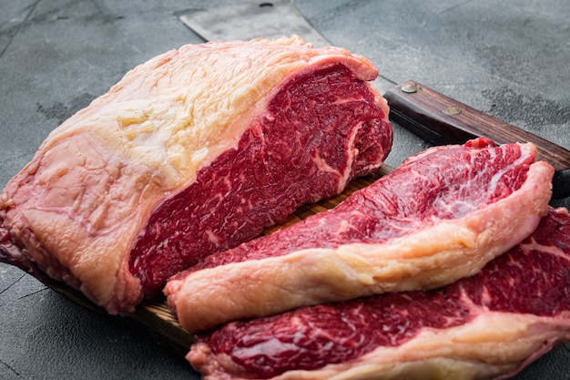 Striploin steak, raw beef butchery cut, on gray table