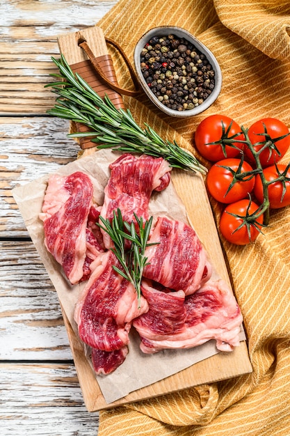 Strips of marbled beef, quick steak on cutting board