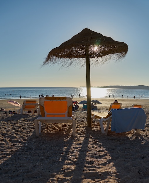 Foto stro parasol en ligstoelen op het pittoreske strand van la lanzada