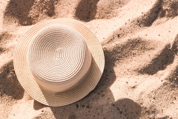 Stro strandhoed met rand voor bescherming tegen de zon op het zand