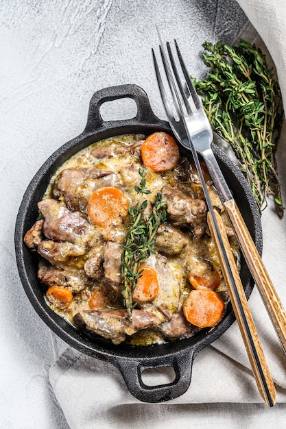 Stroganoff kippenlever met champignons en room. Witte achtergrond. Bovenaanzicht.