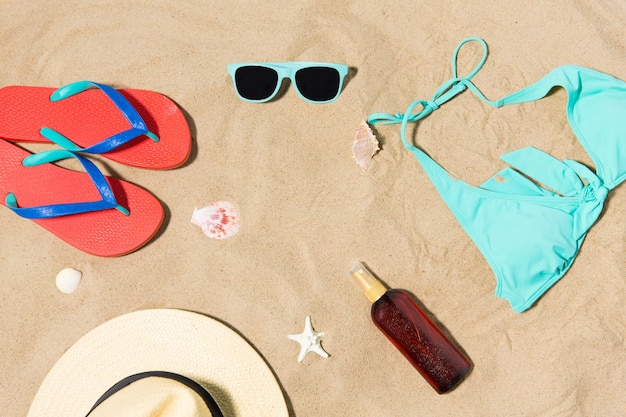 strohoed flip-flops en zonnebril op het strand zand