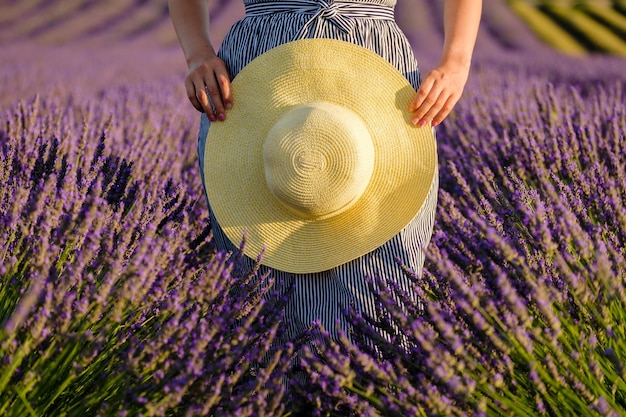 Foto strohoed in de handen van een meisje in een lavendelveld